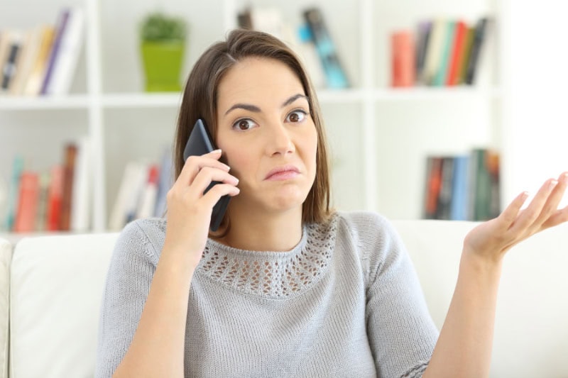 Common Sewer Odors in Your Home: What’s That Smell? A woman talking on the phone looking confused.