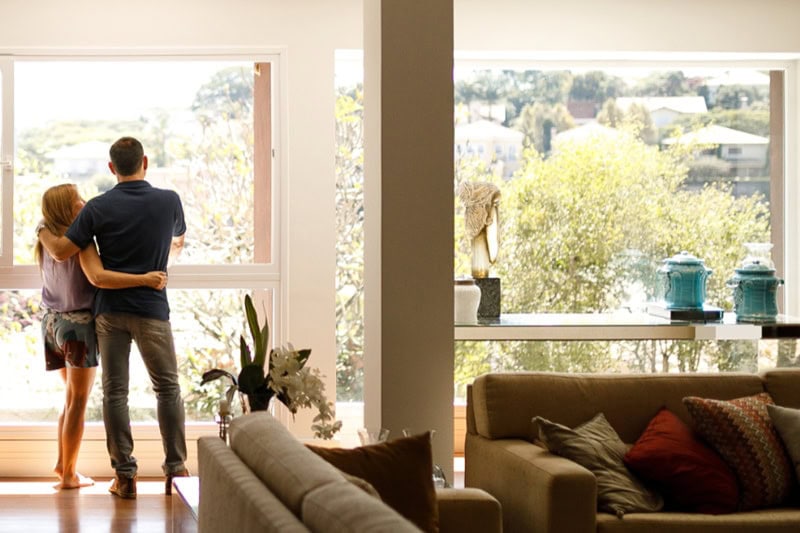 Couple admiring the view from the living room of their house. HVAC contractor in Denver, CO.